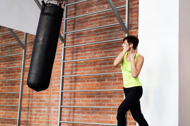 The girl in the gym hitting the punching bag