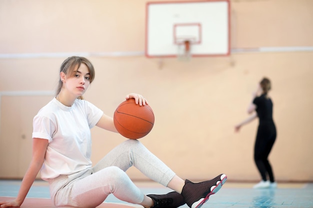 Девушка в спортзале играет в баскетбол