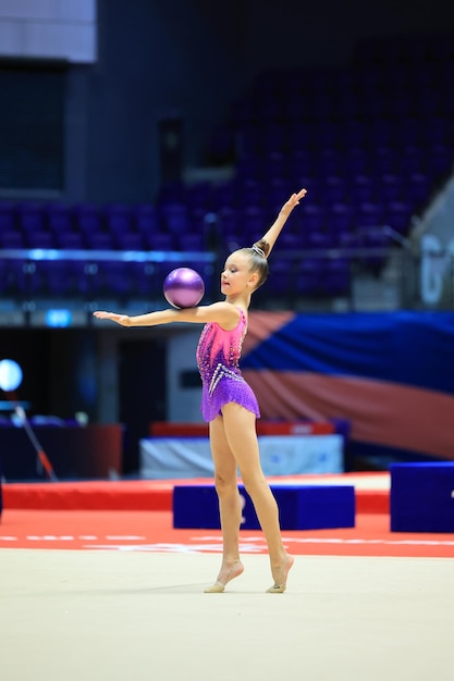 girl gymnast performs an exercise with a ball high quality photo