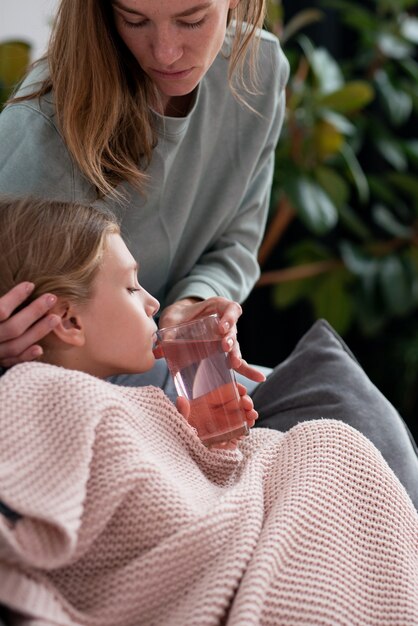 Girl had a cold and her mother brought her a drink