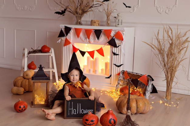 girl in halloween witch costume with pumpkins