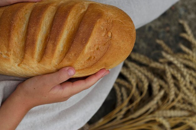 girl hand holding a loaf of white wheat bread