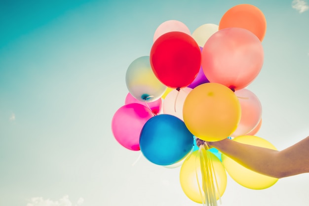 Girl hand holding multicolor balloons 