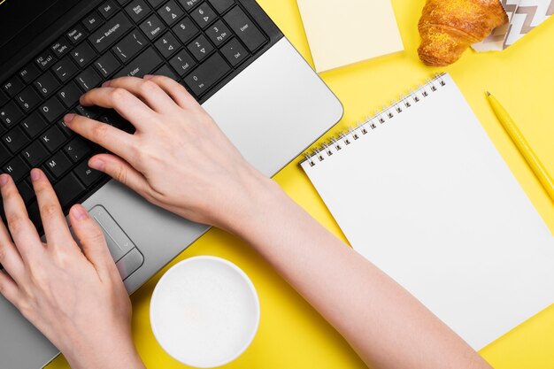 Girl hand works over laptop top view