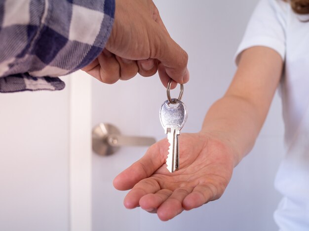 The girl handed a hand to receive the key from the house seller. apartment for hire-purchase after the contract.