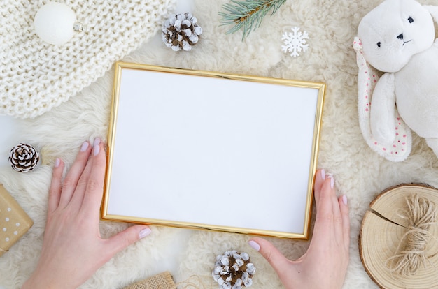 Girl hands holds gold photo frame mock up Christmas, new year background