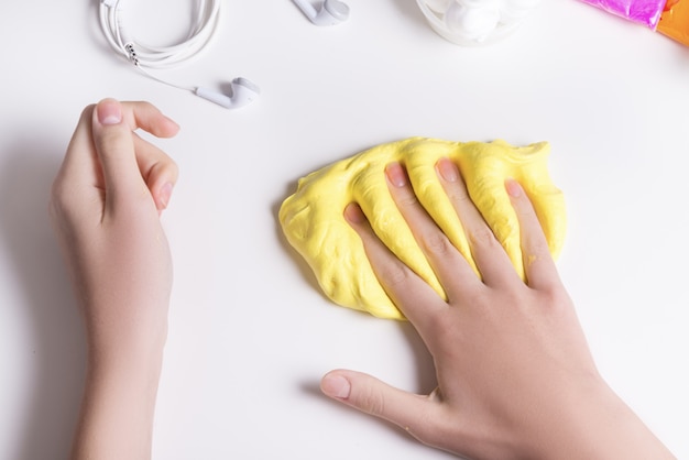 Girl hands playing with yellow slime