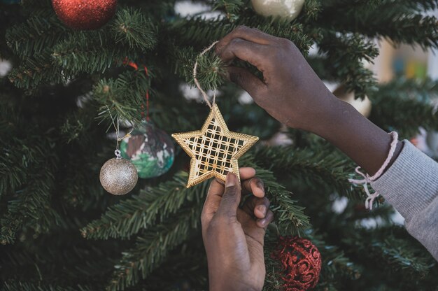 Girl hanging an ornament on Christmas tree