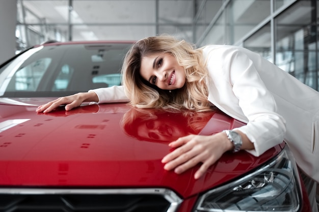 Girl happy to buy her new red car.