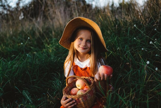 Photo a girl harvesting the summer red apples