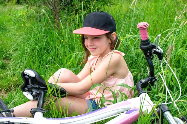 女の子は自転車の車輪を損傷し、修理を行っています