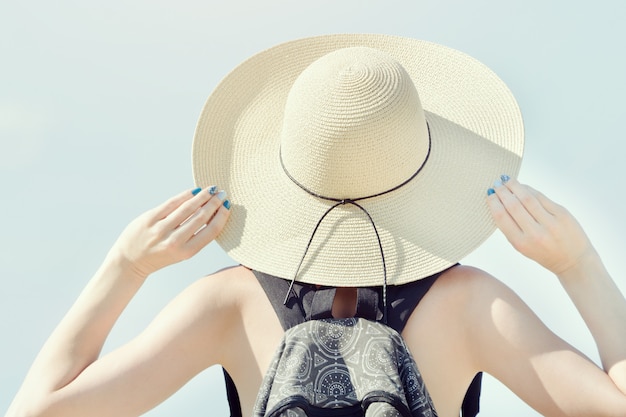 Girl in a hat on a background of clear sky