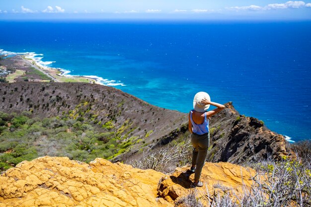 모자를 쓴 소녀는 유명한 코코 분화구 철도 트레일헤드 꼭대기에서 오아후 섬의 파노라마를 즐깁니다.