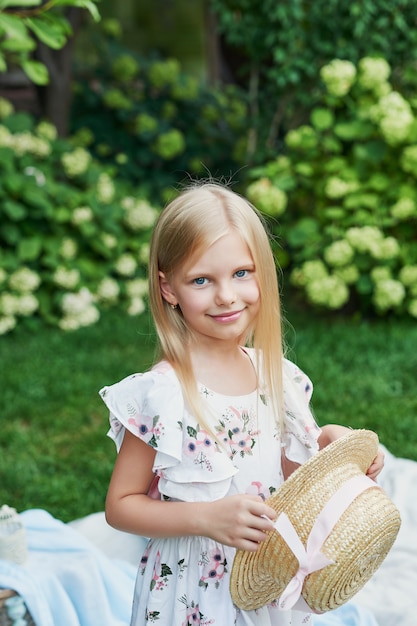 girl in a hat in the garden at a picnic