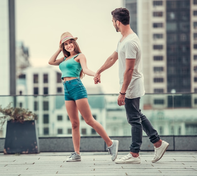 Photo a girl in a hat and a handsome man are walking.