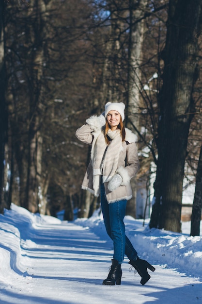 Girl in hat and mittens smiling in the winter