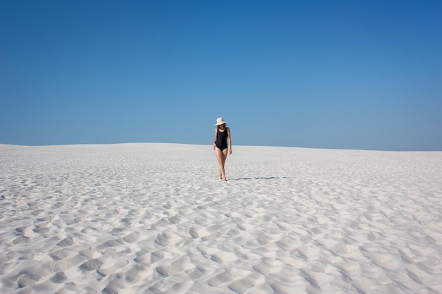 Foto ragazza con cappello sulla sabbia