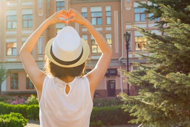 Girl in the hat shows the heart