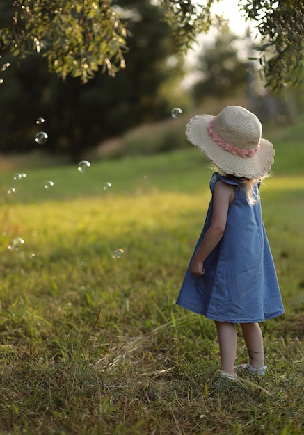 girl in a hat on the street catching soap bubbles