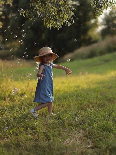 girl in a hat on the street catching soap bubbles