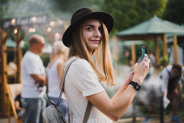 Foto ragazza con cappello assume smartphone