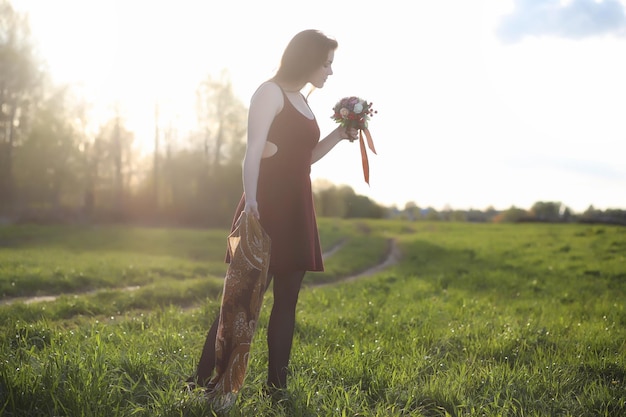 Una ragazza con un cappello durante una passeggiata nel parco una ragazza con un cesto cammina in primavera una ragazza cammina lungo la strada al tramontoxa