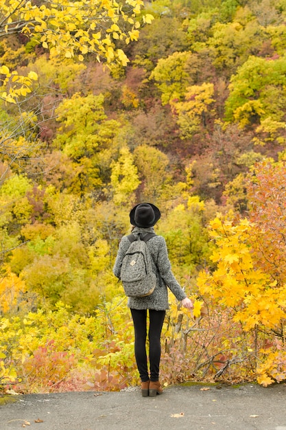 Girl in a hat with a bouquet of yellow leaves