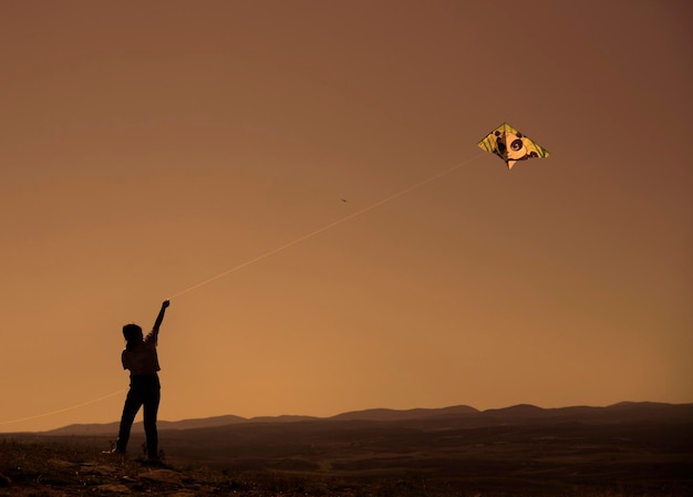 A girl having fun flying a kite outdoors in a park