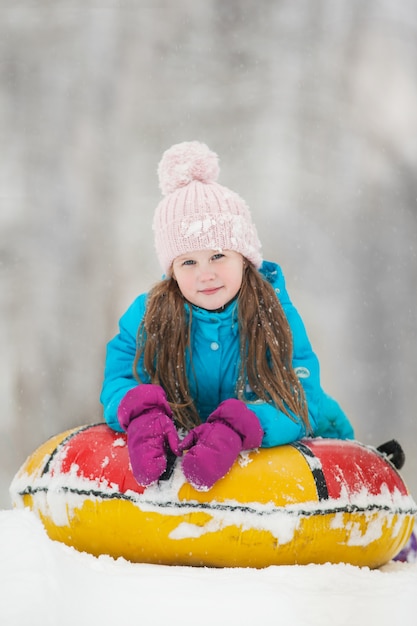 Photo girl having fun on snow tube.girl is riding a tubing.
