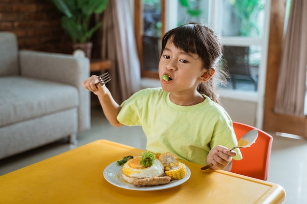 自宅で健康的な朝食を持つ少女