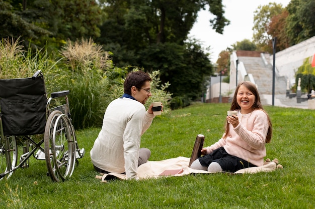 Girl having a picnic with disabled man