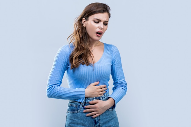 腹痛を持つ少女 腹痛に苦しむ若い女性 女性 胃の痛み 胃に触れる女性 胃の痛みなど 胃の病気の概念