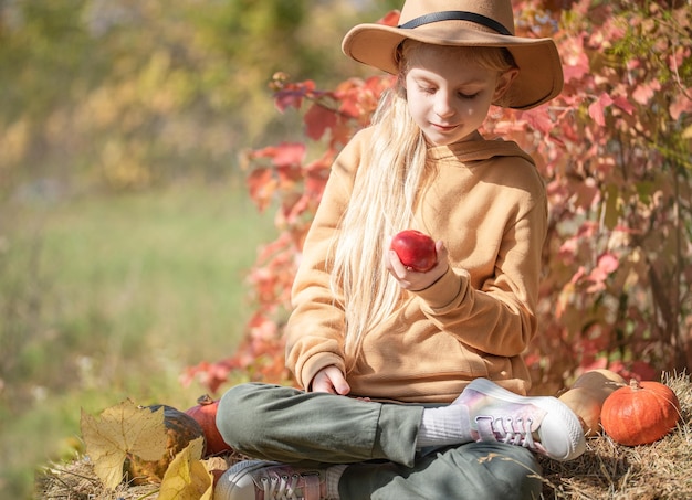 Girl in the hay with pumpkins