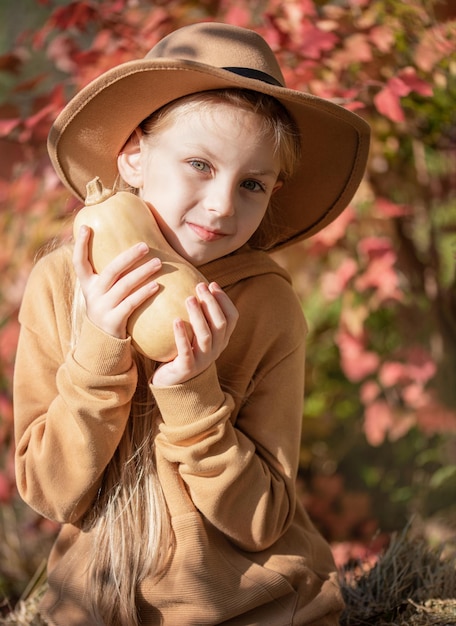 Girl in the hay with pumpkins