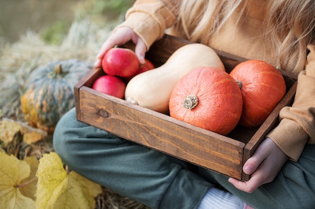 Girl in the hay with pumpkins