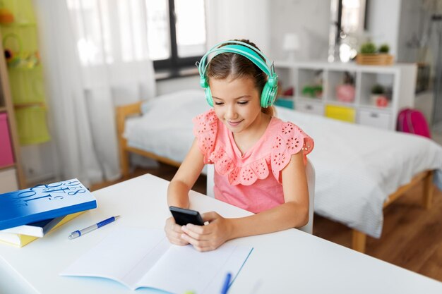 girl in headphones listening to music on cellphone