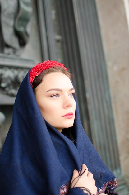 Girl in a headscarf with a red wreath on his head