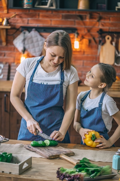 Girl helping to mother on kitchen