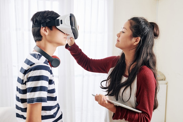 Ragazza che aiuta a indossare gli occhiali vr