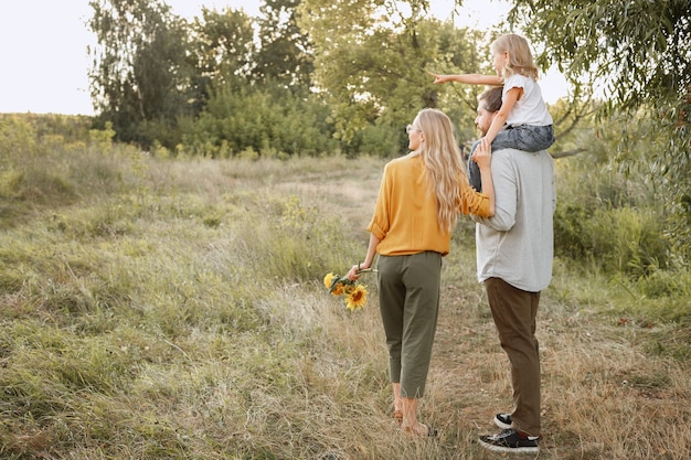 The girl on her father's neck points to the left on a walk. free space for text