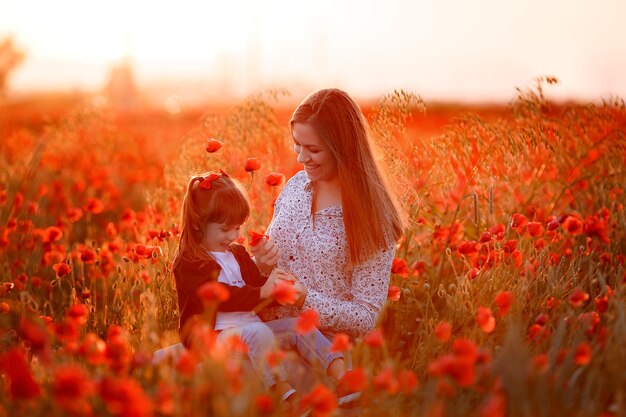 a girl and her mother are having fun in a poppy field