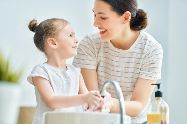 Photo girl and her mother are washing hands