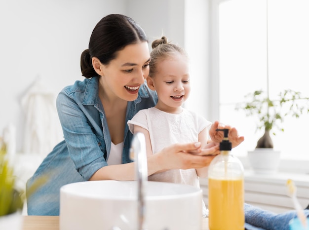 Photo girl and her mother are washing hands