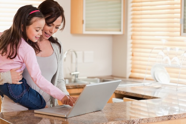 Ragazza e sua madre utilizzando un computer portatile