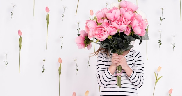 Photo girl hiding behind rose bouquet