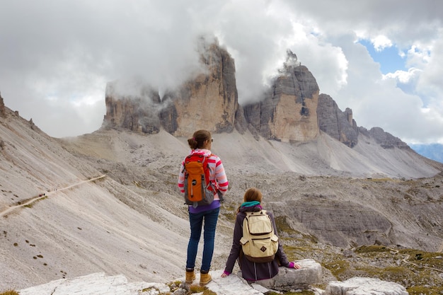 트레 치메 디 라바레도(Tre Cime di Lavaredo)를 바라보며 쉬고 있는 여자 등산객. 돌로미티, 이탈리아.