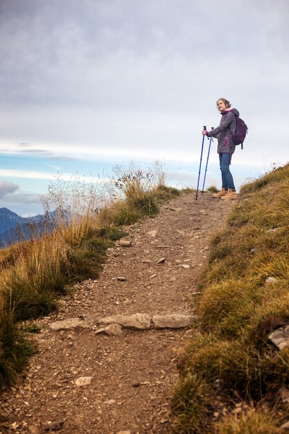 Girl hiker walking along the trail at the mountains Dolomites, Italy