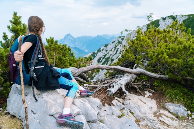 Girl hiking on beautiful summer day in alps mountains