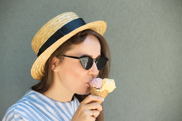 Girl hipster in straw hat is eating ice cream