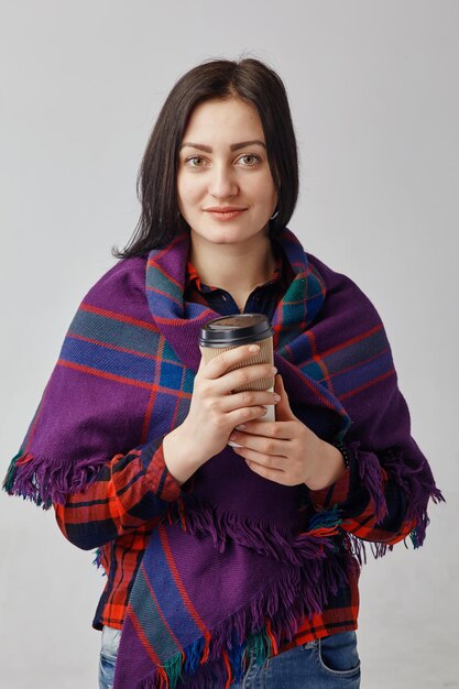 Girl hold a cup for hot drink.She wearing a winter cloth